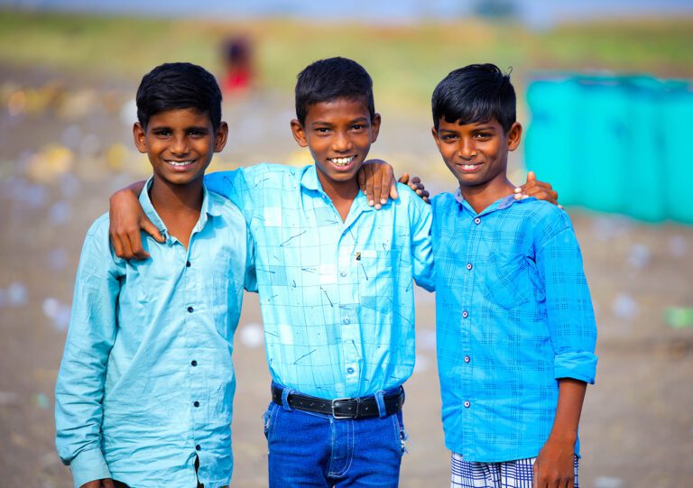 Three boys standing together smiling